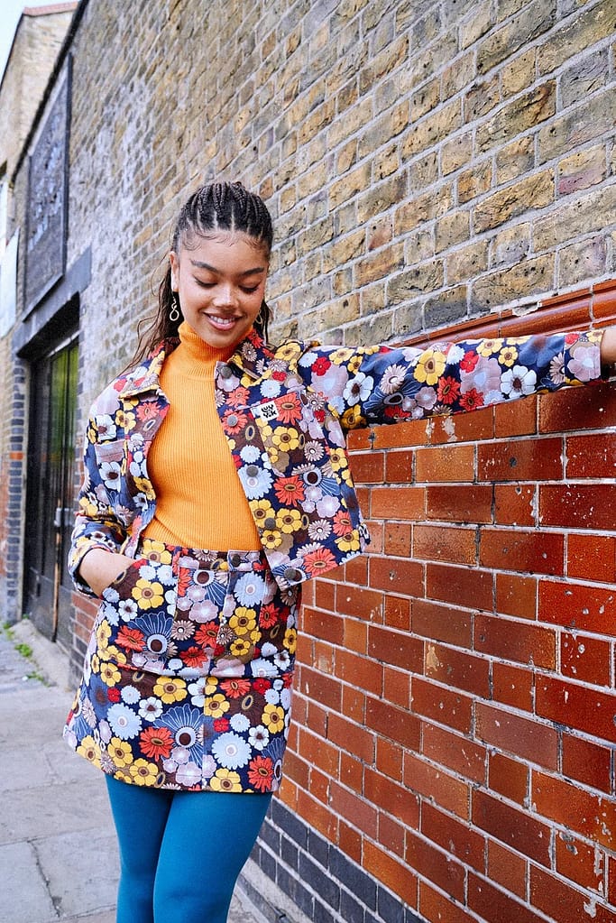 Model wears floral skirt and jacket co-ord 70s fashion style by Lucy and Yak