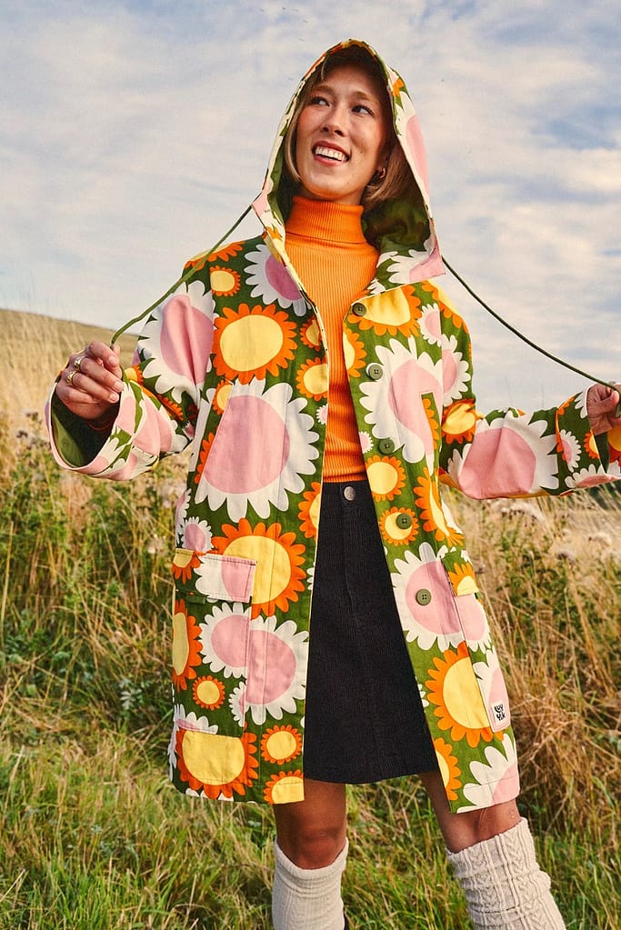 Model wears floral hooded rain coat from Joanie