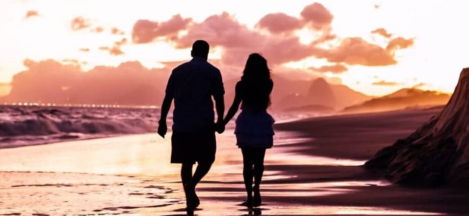 two people walking on a beach - photo by Edgar Chaparro Holiday Romance